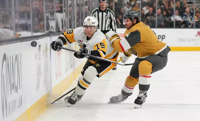 Vegas Golden Knights defenseman Jeremy Lauzon (5) collides with Pittsburgh Penguins center Connor Dewar (19) during the first period of an NHL hockey game Thursday, March 12, 2026, in Las Vegas. (AP Photo/Candice Ward)