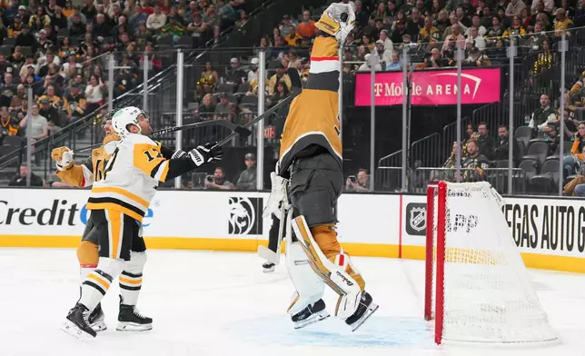 Vegas Golden Knights goaltender Adin Hill (33) stops a shot against Pittsburgh Penguins right wing Bryan Rust (17) during the first period of an NHL hockey game Thursday, March 12, 2026, in Las Vegas. (AP Photo/Candice Ward)
