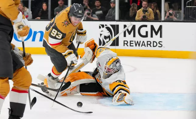 Vegas Golden Knights right wing Mitch Marner (93) scores against Pittsburgh Penguins goaltender Arturs Silovs, right, during the second period of an NHL hockey game, Thursday, March 12, 2026, in Las Vegas. (AP Photo/Candice Ward)
