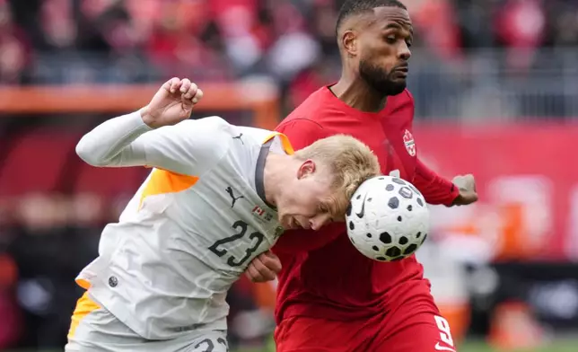 Iceland's Hordor Bjorgvin Magnusson, left, heads the ball away from Canada's Cyle Larin during an international friendly soccer match in Toronto, Saturday March 28, 2026. (Chris Young/The Canadian Press via AP)
