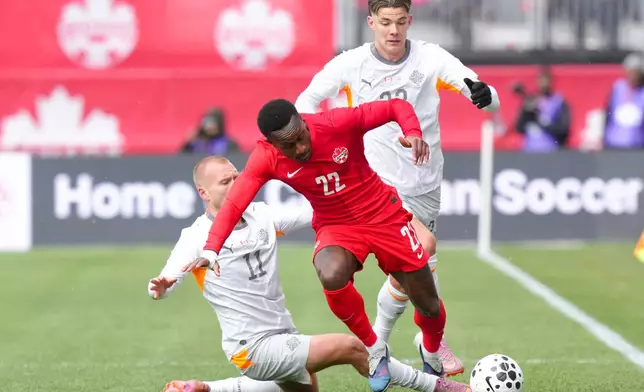 Canada's Richie Laryea, center, gets past Iceland's Jon Dagur Thorsteinsson, left, during an international friendly soccer match in Toronto, Saturday March 28, 2026. (Chris Young/The Canadian Press via AP)