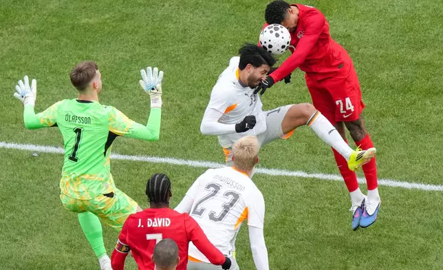 Canada's Daniel Jebbison (24) tries to send a header towards the Iceland goal as he is challenged by Iceland's Mikael Egill Ellertsson during the second half of an international friendly soccer match in Toronto, Saturday March 28, 2026. (Chris Young/The Canadian Press via AP)