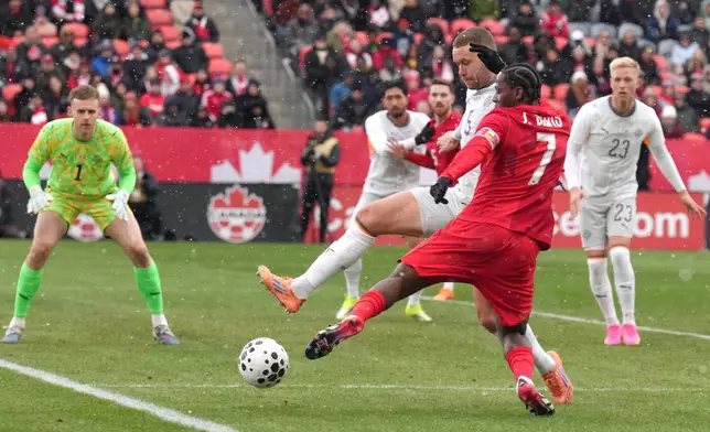 Canada's Jonathan David tries to square the ball despite pressure from Iceland's Sverrir Ingi Ingason during International friendly soccer action in Toronto on Saturday March 28, 2026. (Chris Young/The Canadian Press via AP)