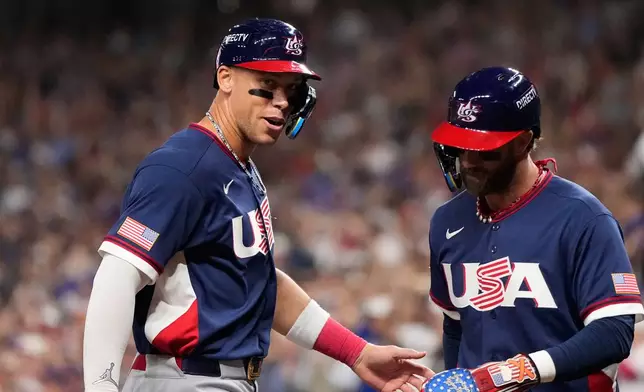 United States right fielder Aaron Judge, left, and first baseman Bryce Harper, right, celebrate as they score during the third inning of a World Baseball Classic quarterfinal game against Canada, Friday, March 13, 2026, in Houston. (AP Photo/David J. Phillip)