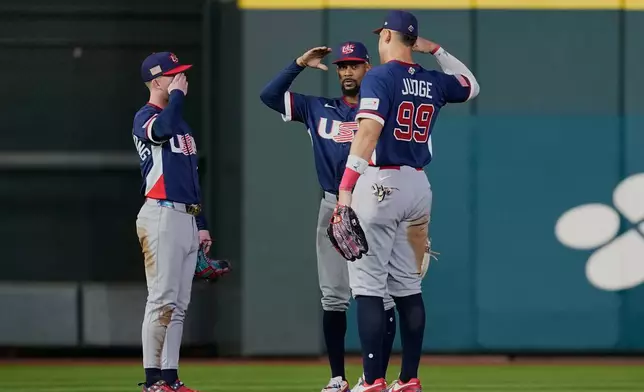 United States right fielder Aaron Judge (99) celebrates with teammates Brice Turang, left, and Byron Buxton, center, after their win over Canada in a World Baseball Classic quarterfinal game, Friday, March 13, 2026, in Houston. (AP Photo/David J. Phillip)