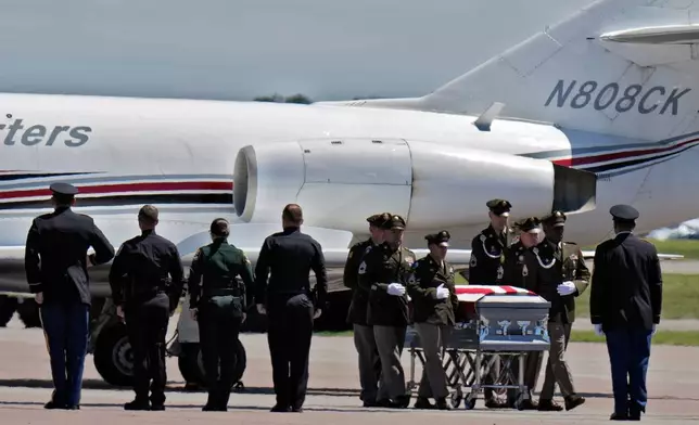 A military honor guard carries the remains of U.S. Army Reserve Maj. Cody Khork, a servicemember killed in the line of duty in the Middle East, to a waiting hearse after arriving at the Lakeland Linder Airport Wednesday, March 18, 2026, in Lakeland, Fla. (AP Photo/Chris O'Meara)