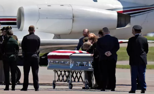 Family members surround the remains of U.S. Army Reserve Maj. Cody Khork, a servicemember killed in the line of duty in the Middle East, after arriving at the Lakeland Linder Airport Wednesday, March 18, 2026, in Lakeland, Fla. (AP Photo/Chris O'Meara)