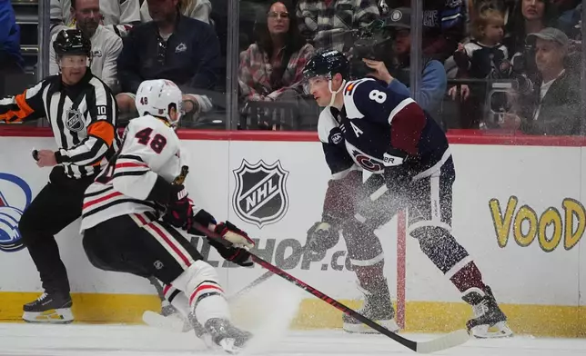 Colorado Avalanche defenseman Cale Makar, right, looks to pass the puck as Chicago Blackhawks defenseman Matt Grzelcyk covers in the second period of an NHL hockey game Saturday, Feb. 28, 2026, in Denver. (AP Photo/David Zalubowski)