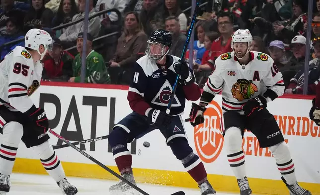 Colorado Avalanche center Brock Nelson, center, loses control of the puck as Chicago Blackhawks right wing Ilya Mikheyev, left, and center Jason Dickinson defend in the second period of an NHL hockey game Saturday, Feb. 28, 2026, in Denver. (AP Photo/David Zalubowski)