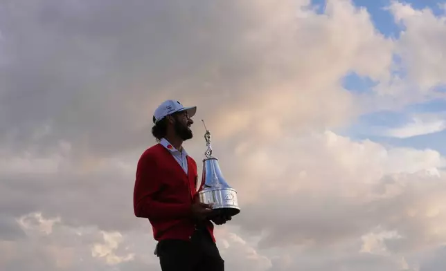 Akshay Bhatia smiles as he holds the championship trophy after winning the Arnold Palmer Invitational at Bay Hill golf tournament Sunday, March 8, 2026, in Orlando, Fla. (AP Photo/Matt Slocum)