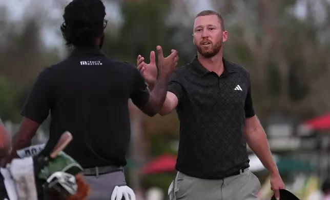 Daniel Berger, right, greets Akshay Bhatia on the 16th hole during the third round of the Arnold Palmer Invitational at Bay Hill golf tournament Saturday, March 7, 2026, in Orlando, Fla. (AP Photo/Matt Slocum)