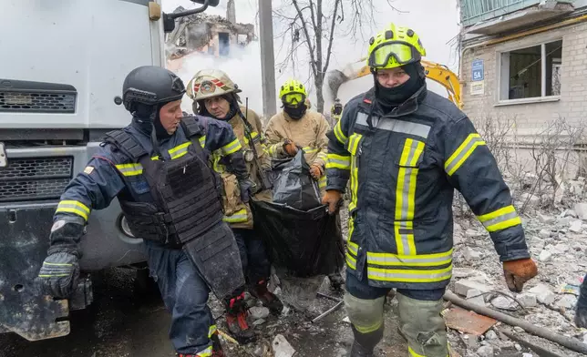 Rescuers carry a body that they extracted from under the rubble of an apartment building following Russia's missile attack in Kharkiv, Ukraine, Saturday, March 7, 2026. (AP Photo/Andrii Marienko)