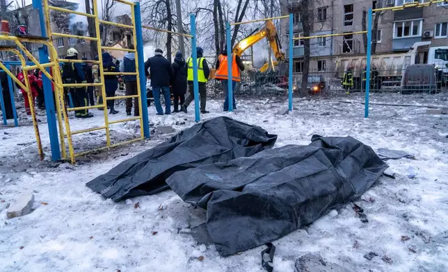 Bodies of local residents lie on the snow in plastic bags near a damaged apartment building following Russia's missile attack in Kharkiv, Ukraine, Saturday, March 7, 2026. (AP Photo/Andrii Marienko)