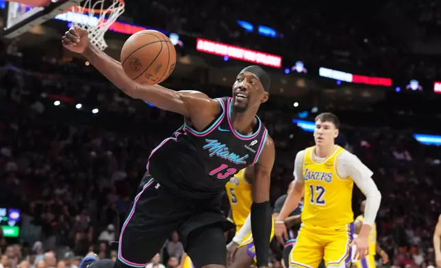 Miami Heat center Bam Adebayo (13) goes for a loose ball during the first half of an NBA basketball game against the Los Angeles Lakers, Thursday, March 19, 2026, in Miami. (AP Photo/Lynne Sladky)