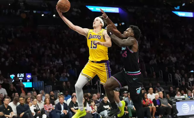 Los Angeles Lakers guard Austin Reaves (15) hopes to the basket as Miami Heat guard Davion Mitchell (45) defends during the first half of an NBA basketball game, Thursday, March 19, 2026, in Miami. (AP Photo/Lynne Sladky)