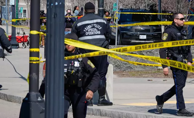 Law enforcement officials work a crime scene at the Forest Hills train station in the Jamaica Plain neighborhood, Friday, March 20, 2026, in Boston. (AP Photo/Charles Krupa)
