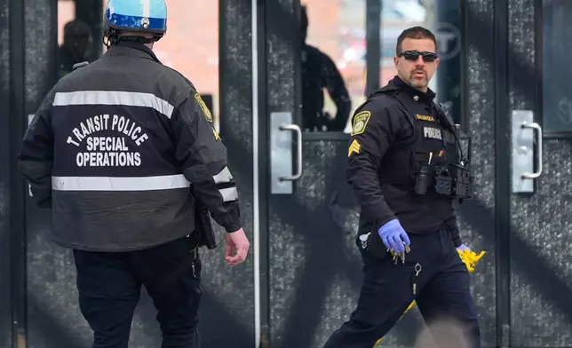 Law enforcement officials work a crime scene at the Forest Hills train station in the Jamaica Plain neighborhood, Friday, March 20, 2026, in Boston. (AP Photo/Charles Krupa)