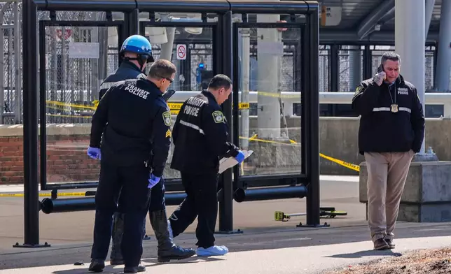Law enforcement officials work a crime scene at the Forest Hills train station in the Jamaica Plain neighborhood, Friday, March 20, 2026, in Boston. (AP Photo/Charles Krupa)
