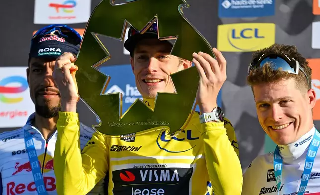 Jonas Vingegaard of Denmark, wearing the overall leader's yellow jersey, center, Daniel Martinez Poveda of Colombia,left and second place, and Georg Steinhauser of Germany, third place and wearing the best young rider's white jersey, celebrate on the podium after the last stage of the Paris Nice cycling race with start and finish in Nice, France, Sunday, March 15, 2026. (AP Photo/Philippe Magoni)