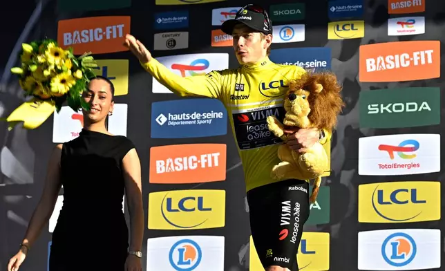 Jonas Vingegaard of Denmark, wearing the overall leader's yellow jersey, celebrates on the podium after the last stage of the Paris Nice cycling race with start and finish in Nice, France, Sunday, March 15, 2026. (AP Photo/Philippe Magoni)