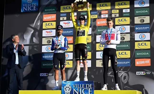 Jonas Vingegaard of Denmark, wearing the overall leader's yellow jersey, center, Daniel Martinez Poveda of Colombia,left and second place, and Georg Steinhauser of Germany, third place and wearing the best young rider's white jersey, celebrate on the podium after the last stage of the Paris Nice cycling race with start and finish in Nice, France, Sunday, March 15, 2026. (AP Photo/Philippe Magoni)