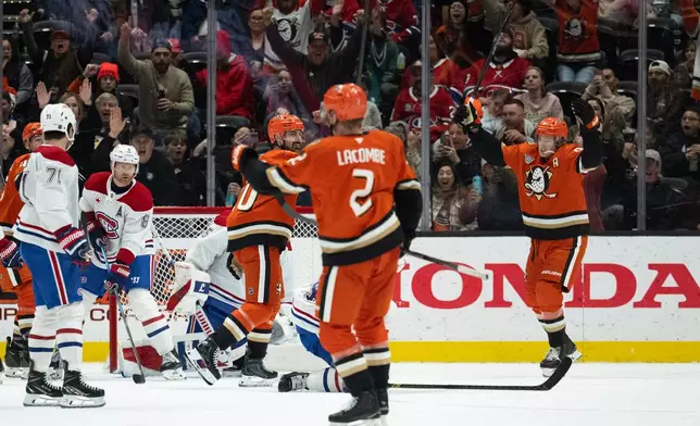 Anaheim Ducks center Leo Carlsson, right, and left wing Chris Kreider, center left, react after a goal by defenseman Jackson LaCombe (2) during the second period of an NHL hockey game against the Montreal Canadiens, Friday, March 6, 2026, in Anaheim, Calif. (AP Photo/Kyusung Gong)