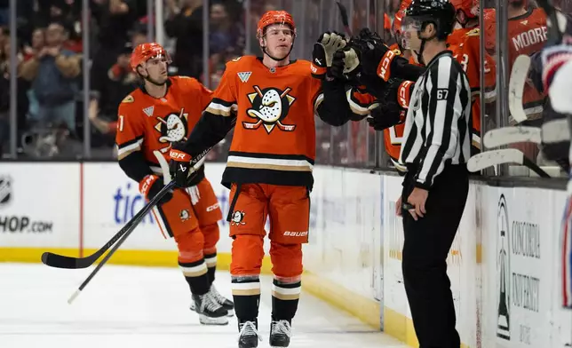 Anaheim Ducks defenseman Jackson LaCombe, center, celebrates with the bench after his goal during the second period of an NHL hockey game against the Montreal Canadiens, Friday, March 6, 2026, in Anaheim, Calif. (AP Photo/Kyusung Gong)