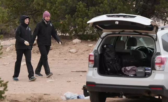 Police and investigators conduct an investigation at Cocks Comb trailhead where two woman were killed Wednesday, on Thursday, March 5, 2026, outside Teasdale, Utah. (AP Photo/George Frey)