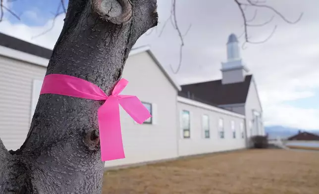 A pink ribbon hangs on a tree outside the Church of Jesus Christ of Latter-Day Saints Thursday, March 5, 2026, in Lyman, Utah, in honor of a woman that was killed a day earlier. (AP Photo/George Frey)