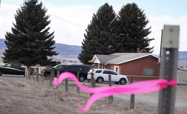 A pink ribbons hangs on a pole Thursday, March 5, 2026, in Lyman, Utah, in front of the house of a woman that was killed a day earlier. (AP Photo/George Frey)