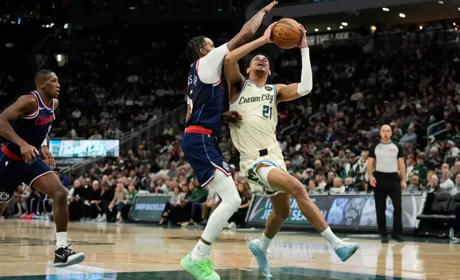Milwaukee Bucks' Ousmane Dieng (21) drives to the basket against LA Clippers' Derrick Jones Jr. during the second half of an NBA basketball game Sunday, March 29, 2026, in Milwaukee. (AP Photo/Aaron Gash)