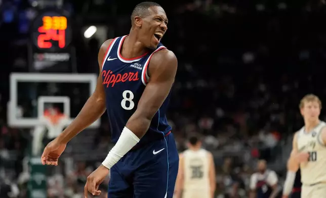 LA Clippers' Kris Dunn smiles as he looks to the Milwaukee Bucks bench during the second half of an NBA basketball game Sunday, March 29, 2026, in Milwaukee. (AP Photo/Aaron Gash)