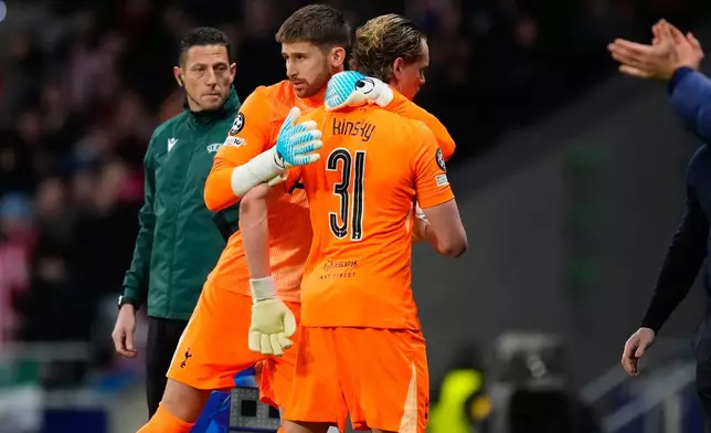 Tottenham's goalkeeper Antonin Kinsky, right, is greeted by Tottenham's goalkeeper Guglielmo Vicario after being substituted during the first leg of the Champions League round of 16 soccer match between Atletico Madrid and Tottenham in Madrid, Spain, Tuesday, March 10, 2026. (AP Photo/Jose Breton)