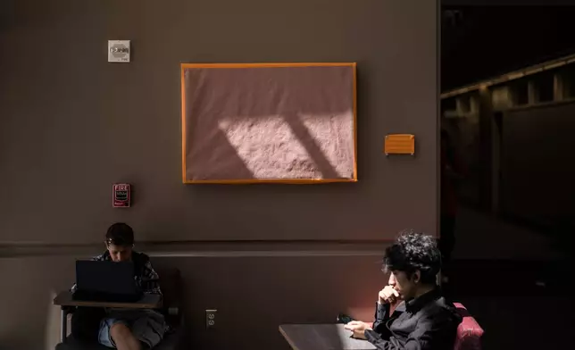 Students sit near a covered painting of Cesar Chavez at the Santa Ana College in Santa Ana, Calif., Thursday, March 19, 2026. (AP Photo/Jae C. Hong)