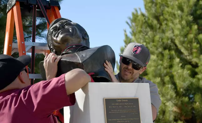 City worker Zak Merten removes a bust of César Chavez at César E. Chavez Park in Denver on Thursday, March 19, 2026. (AP Photo/Thomas Peipert)