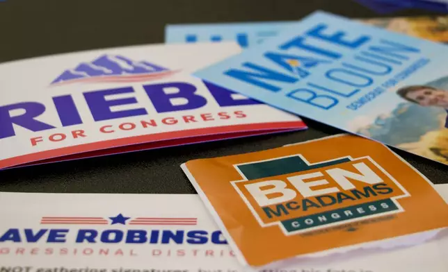 Candidate handouts are displayed at an event for candidates running to represent Utah's new Democratic-leaning congressional district, March 21, 2026, in Taylorsville, Utah. (AP Photo/Hannah Schoenbaum)