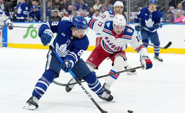 Toronto Maple Leafs forward Nicholas Robertson (89) drives the puck past New York Rangers defenceman Will Borgen (17) during the second period of an NHL hockey game in Toronto, Wednesday, March 25, 2026. (Nathan Denette/The Canadian Press via AP)