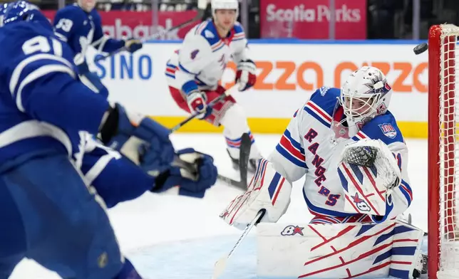 Toronto Maple Leafs forward John Tavares (91) hits the post on a goal attempt as New York Rangers goaltender Igor Shesterkin (31) reacts during the second period of an NHL hockey game in Toronto, Wednesday, March 25, 2026. (Nathan Denette/The Canadian Press via AP)