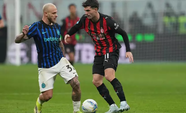 Inter Milan's Federico Dimarco, left, and AC Milan's Christian Pulisic fight for the ball during the Serie A soccer match between AC Milan and Inter Milan, in Milan, Italy, Sunday, March 8, 2026. (AP Photo/Antonio Calanni)