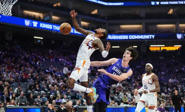 Phoenix Suns guard Jalen Green (4) loses the ball while going to the basket against Sacramento Kings center Maxime Raynaud (42) during the first half of an NBA basketball game Tuesday, March 3, 2026, in Sacramento, Calif. (AP Photo/Alan Greth)