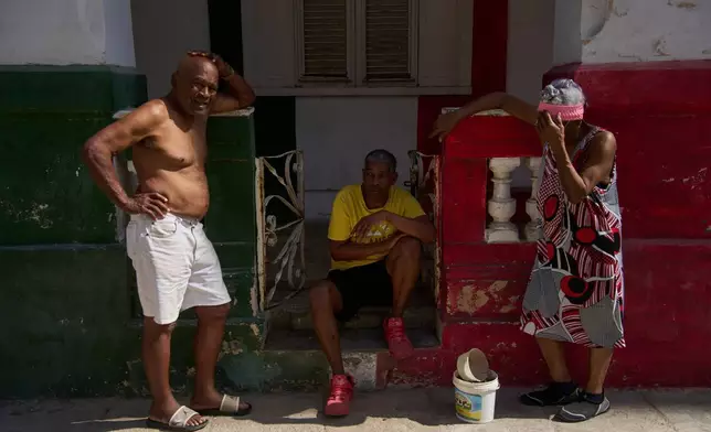 People lounge on a porch during a blackout in Havana, Wednesday, March 4, 2026. (AP Photo/Ramon Espinosa)