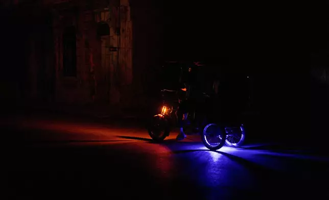 A vehicle drives down a street during a blackout in Havana, Wednesday, March 4, 2026. (AP Photo/Ramon Espinosa)