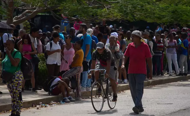 People wait to take public transportation during a blackout in Havana, Wednesday, March 4, 2026. (AP Photo/Ramon Espinosa)