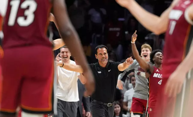 Miami Heat head coach Erik Spoelstra, center, and players react during the second half of an NBA basketball game against the Washington Wizards, as center Bam Adebayo (13) plays on his way to scoring 83 points, the second-highest single game total in NBA history, in an NBA basketball game, Tuesday, March 10, 2026, in Miami. (AP Photo/Rebecca Blackwell)