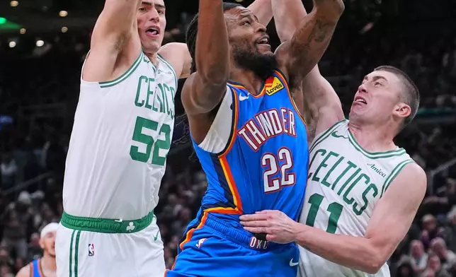 Oklahoma City Thunder guard Cason Wallace (22) drives to the basket against Boston Celtics guard Payton Pritchard (11) and center Luka Garza (52) during the first half of an NBA basketball game, Wednesday, March 25, 2026, in Boston. (AP Photo/Charles Krupa)