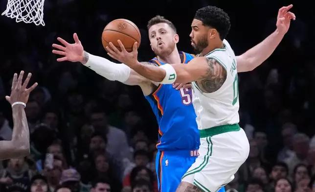 Boston Celtics forward Jayson Tatum, right, drives to the basket against Oklahoma City Thunder center Isaiah Hartenstein (55) during the first half of an NBA basketball game, Wednesday, March 25, 2026, in Boston. (AP Photo/Charles Krupa)