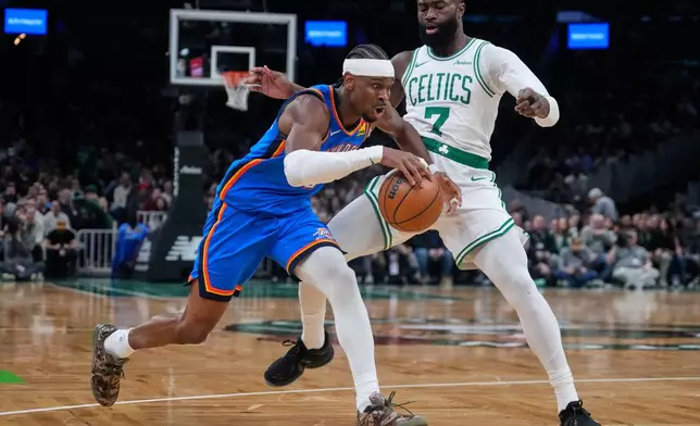 Oklahoma City Thunder guard Shai Gilgeous-Alexander, left, drives to the basket against Boston Celtics guard Jaylen Brown (7) during the first half of an NBA basketball game, Wednesday, March 25, 2026, in Boston. (AP Photo/Charles Krupa)