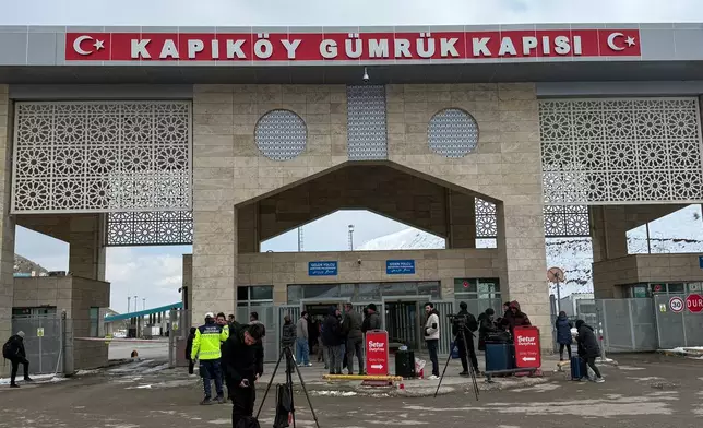 People, mostly Iranians, wait after crossing from Iran at the Kapikoy border crossing in eastern Van province, Turkey, Thursday, March 5, 2026. (AP Photo/Serra Yedikardes)