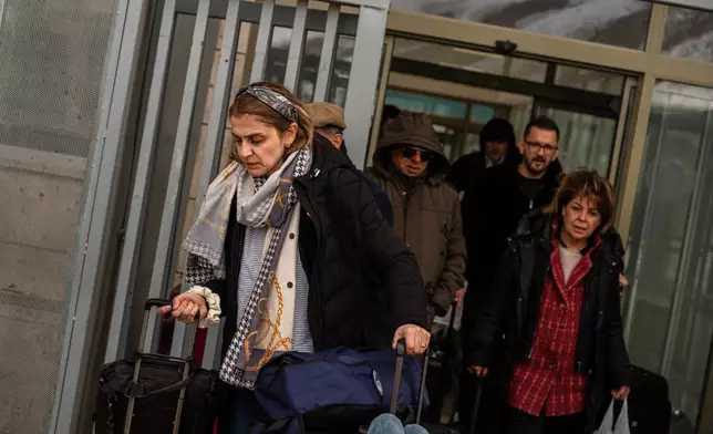 People, mostly Iranians who crossed from Iran at the Kapikoy border crossing, pull luggage in Turkey's eastern Van province, Friday, March 6, 2026. (AP Photo/Murat Kocabas)