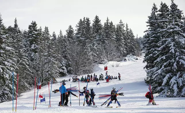 Coach Jeremie Barnier and his athletes remove the stakes after a training ski session in Lans-en-Vercors, near Grenoble, France, Friday, Feb. 13, 2026. (AP Photo/Laurent Cipriani)
